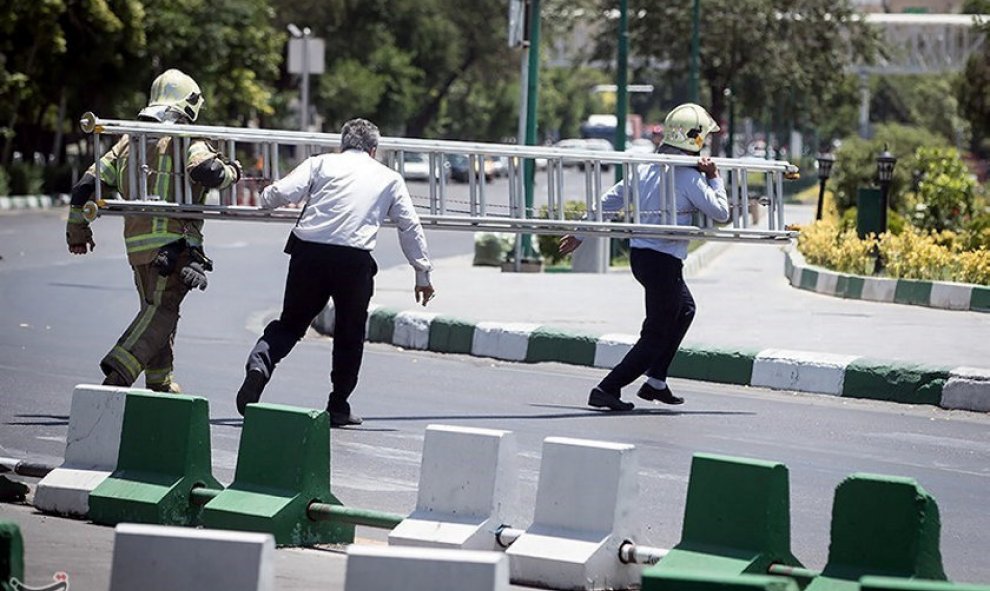 Miembros de la defensa civil de Irán corren durante el ataque al Parlamento en Teherán. / REUTERS