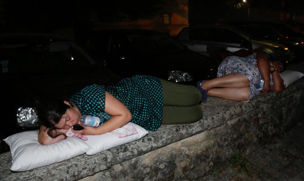 Miles de personas han sido evacuadas de sus casas en toda la zona. Estas dos mujeres duermen al raso tras abnadonar sus casas en  Pedrogao Grande. | MIGUEL VIDAL (REUTERS)