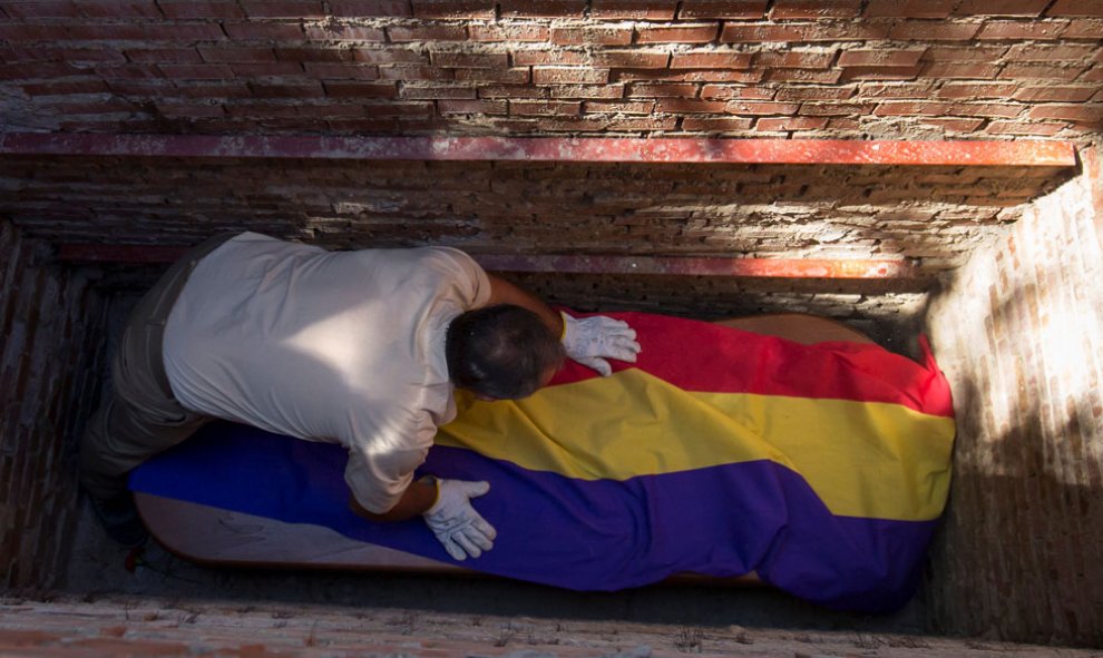 La tumba de Timoteo en el fondo del nicho. Aplausos en honor a todos los desaparecidos que no han podido descansar en paz.- REUTERS