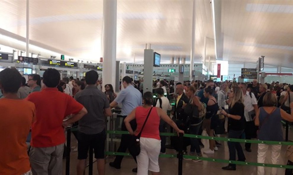 Pasajeros haciendo cola en el control en el aeropuerto barcelonés de El Prat. E.P.