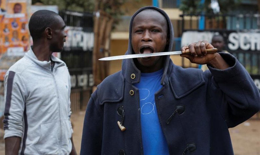 Un manifestante keniata lame la hoja de un cuchillo con su lengua.EFE/Dai Kurokawa