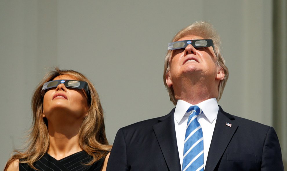 El presidente de EEUU, Donald Trump, y su esposa Melania observan el eclipse de Sol en la Casa Blanca, en Washington (EEUU). REUTERS/Kevin Lamarque