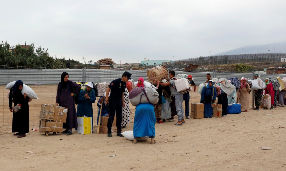 El trabajo es abrumador y lleno de riesgos: cuando abren las puertas de la frontera comienza la lucha entre ellas para conseguir un espacio por dónde cruzar: algunos comerciantes han muerto en estampidos / REUTERS - Youssef Boudal