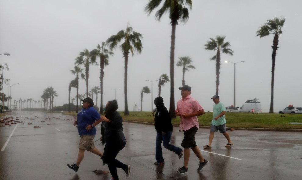 Un grupo de gente corre a refugiarse del temporal levantado por el huracán Harvey.REUTERS/Adrees Latif
