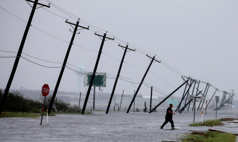 Un hombre cruza una carretera inundada por las lluvias del huracán Harvey. REUTERS/Adrees Latif