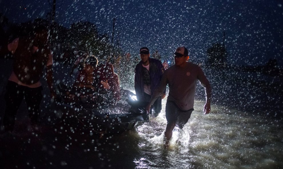 Varios voluntarios ayudan a empujar un barco con evacuados durante una tormenta causada por lel huracán Harvey en el este de Houston, Texas, (EEUU).- REUTERS / Adrees Latif