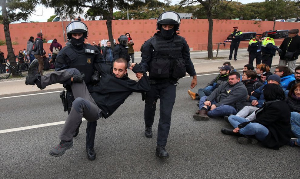 Los Mossos se llevan a una persona en Barcelona durante la huelga en Catalunya. REUTERS/Albert Gea