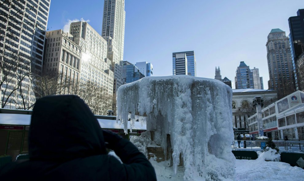 Varias personas se hacen fotos en la fuente congelada de Bryant Park, en Nueva York. JEWEL SAMAD / AFP