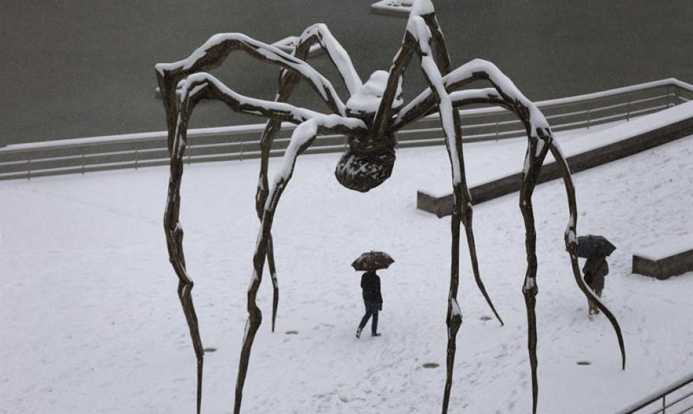 La escultura 'mama', de Louise Bourgeois, bajo una gran capa de nieve, en el museo Guggenheim de Bilbao. / EFE