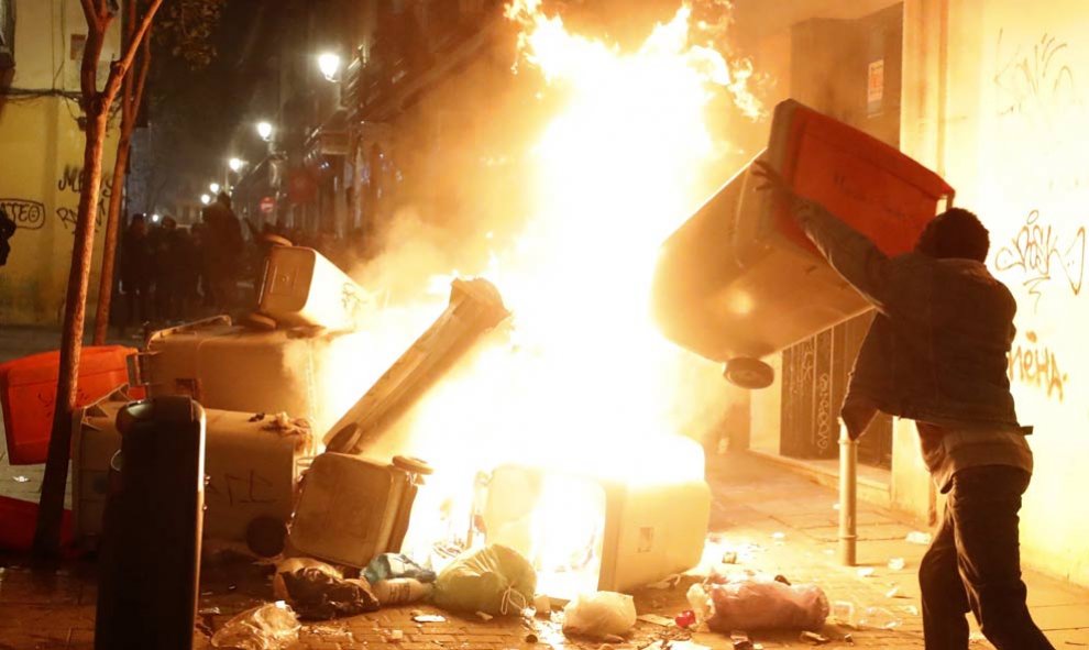 Contenedores incendiados en la calle Mesón de Paredes con la calle del Oso, en el barrio de Lavapiés de Madrid. | JAVIER LIZÓN (EFE)