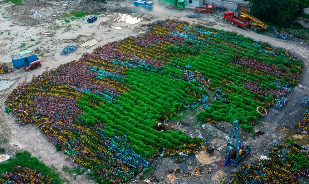 Miles de bicicletas de empresas de vehículos compartidos,  abandonadas se ven en un estacionamiento temporal en Shanghái. La industria del uso compartido de bicicletas ha demostrado ser tremendamente popular entre los habitantes de las ciudades chinas, pe