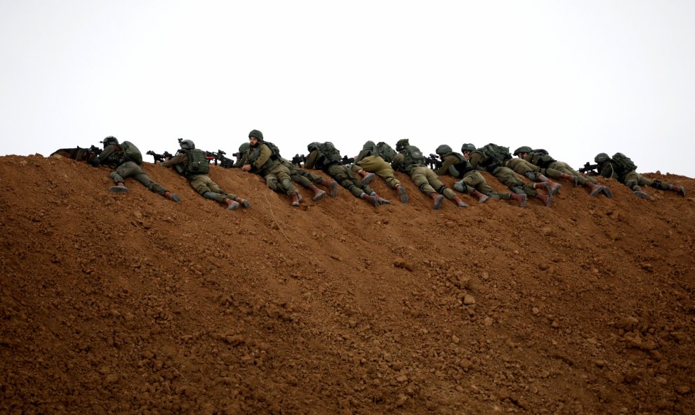 Los soldados israelíes toman posiciones junto a la valla fronteriza en el lado israelí de la frontera con el norte de la Franja de Gaza.- REUTERS / Amir Cohen