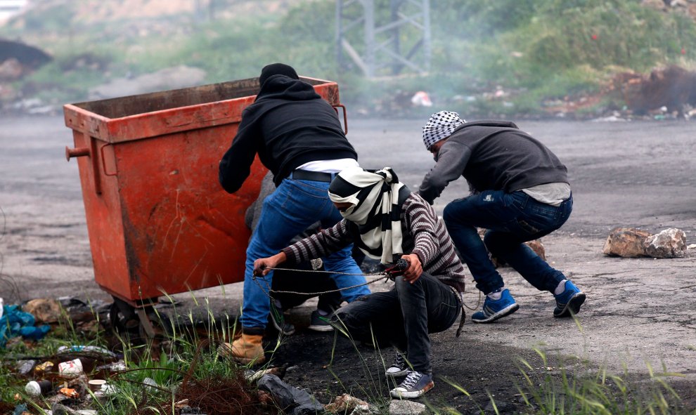 Varios palestinos lanzan piedras durante los enfrentamientos con soldados israelíes en la ciudad cisjordana de Ramala.-  EFE/Alaa Badarneh