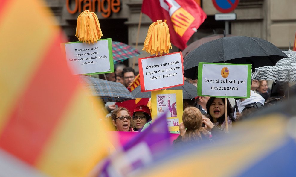 Varias personas muestra pancartas en la manifestación celebrada hoy por el centro de Barcelona bajo el lema: "¡Ahora nos toca a nosotros! + igualdad, + empleo + salarios + pensiones", en favor de unas pensiones y salarios dignos en la tradicional moviliza