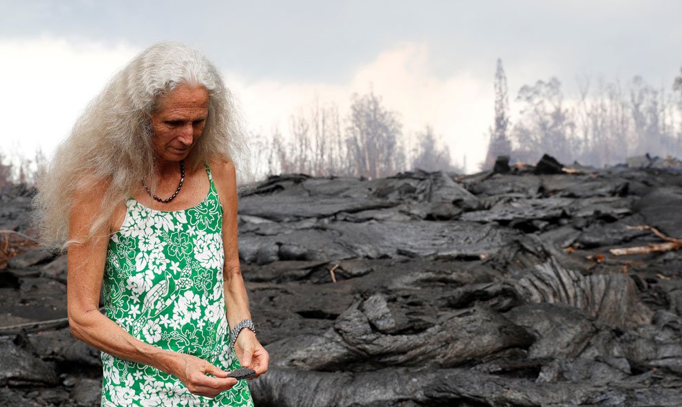 Una mujer se maravilla ante un colorido fragmento de roca de lava cerca del reciente flujo de lava en Leilani Estates, Pahoa, Hawai. / Reuters