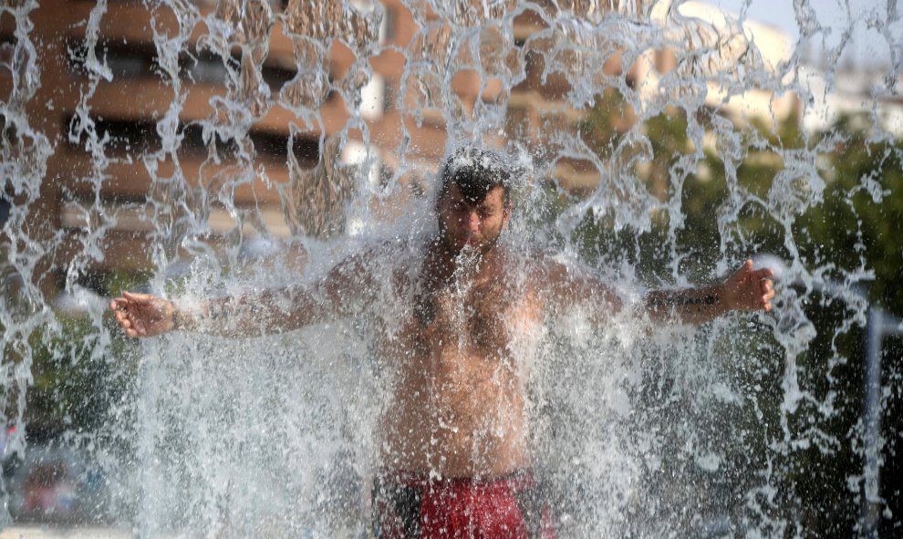 Un hombre se refresca en una fuente pública de Córdoba, una de las ciudades más afectadas por esta fuerte ola de calor que está dejando temperaturas récords tanto en España como en gran parte de Europa. EFE/Rafa Alcaide