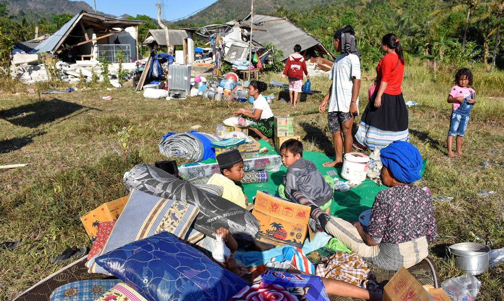 Los residentes en Indonesia esperan fuera de sus casa con todas las pertenencias que han podido salvar tras el terremoto. / Reuters