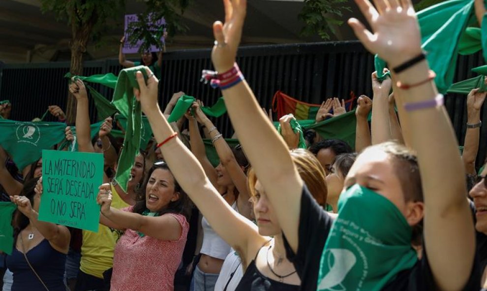 Decenas de personas se suman al "pañuelazo" internacional a favor del aborto legal en Argentina frente a la embajada de ese país en Madrid. / EFE