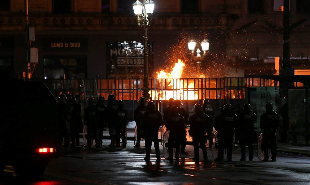Policías son vistos frente a una barricada cuando activistas pro-abortistas encendieron fuego en Buenos Aires - REUTERS/Agustin Marcarian