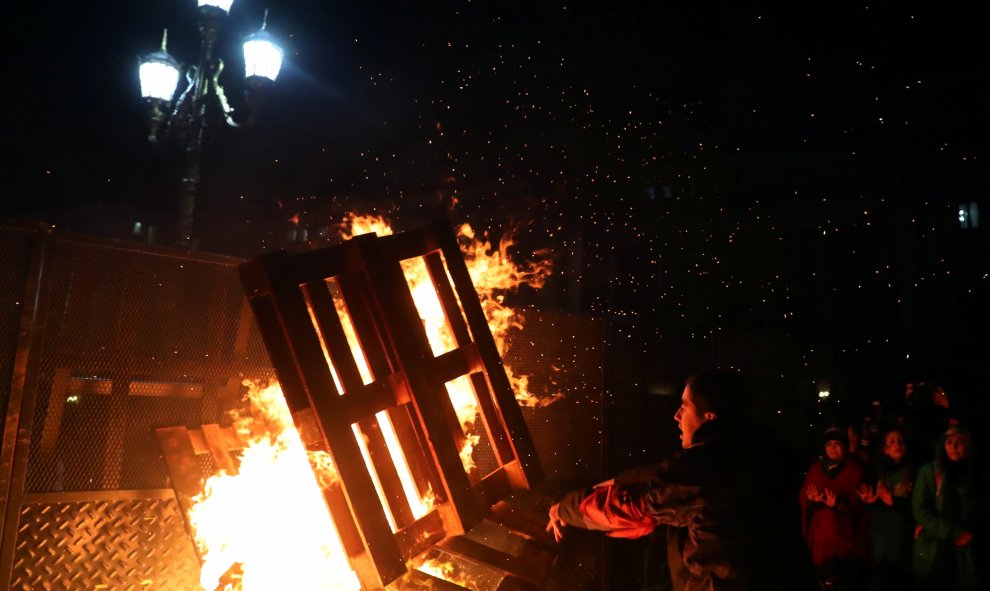 Un manifestante tira madera a un fuego originado por los activistas decepcionados por los resultados de la votación. / REUTERS - Marcos Brindicci