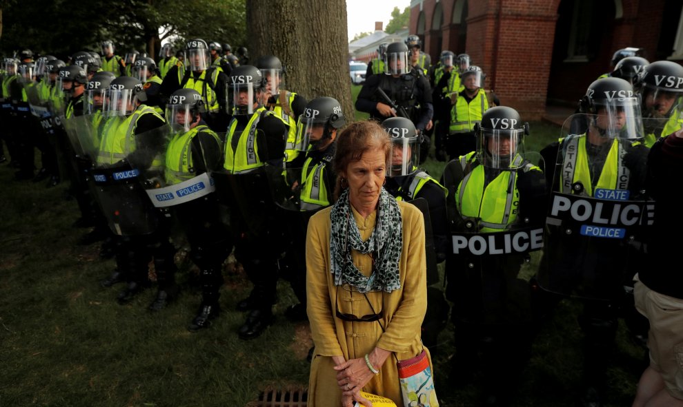 Una mujer da la espalda al cordón policial formado para no dejar pasar a los manifestantes al parque Robert E. Lee | REUTERS