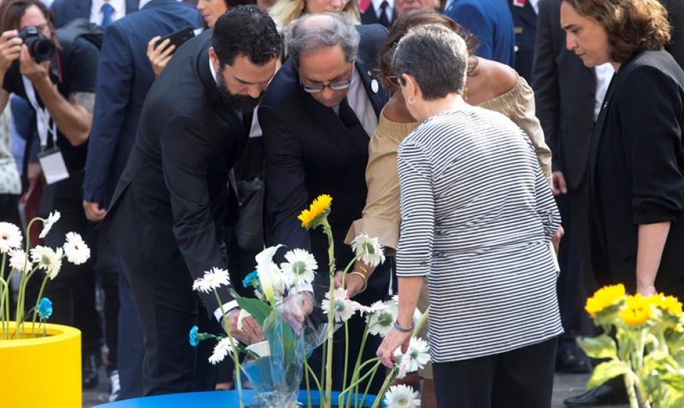 Algunas autoridades también han querido rendir homenaje simbólicamente dejando flores en los maceteros que se han habilitado para ello en Barcelona. | EFE / Quique García