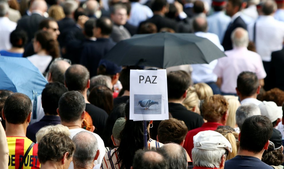 Pancarta exhibida por un asistenta al acto en homenaje a las víctimas del 17-A en Plaza Catalunya | Reuters / Albert Salame