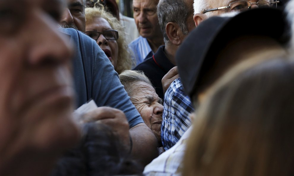 Una pensionista es aplastada mientras espera fuera de una sucursal del Banco Nacional para recibir parte de su pensión en Atenas. / REUTERS - ALKIS KONSTANTINIDIS