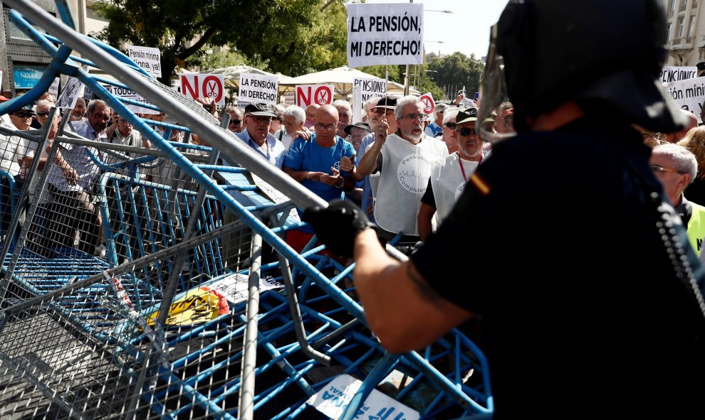 Un grupo de pensionistas que se concentraron en el Congreso de los Diputados pidiendo mejoras en sus prestaciones derriban las vallas que protegían el edificio de la cámara baja donde hoy se celebraba una reunión del Pacto de Toledo. EFE/Mariscal