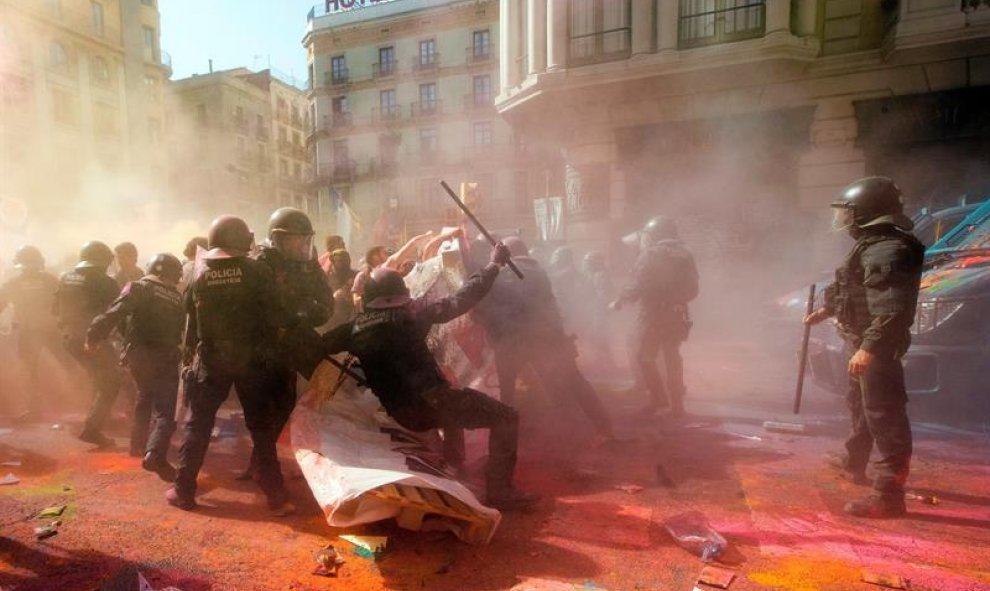 Un Mosso d'Esquadra cae en las cargas contra los independentistas. | Marta Pérez / EFE