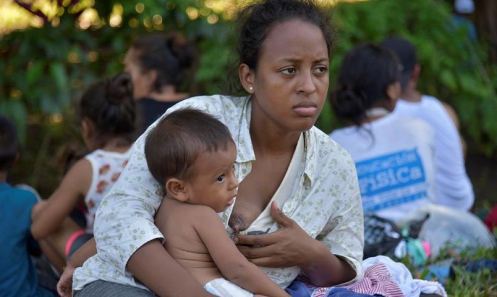 Una madre con su hijo en brazos tras haber logrado instalarse en Ciudad Cuauhtémoc. EFE/Rodrigo Pardo