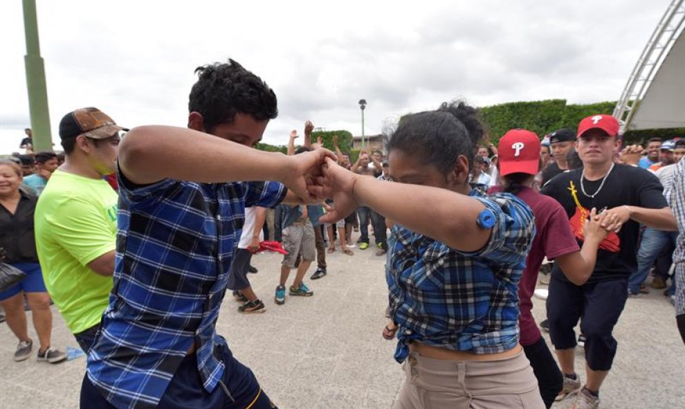 Migrantes hondureños bailan tras haber logrado instalarse en Ciudad Cuauhtémoc. EFE/Rodrigo Pardo