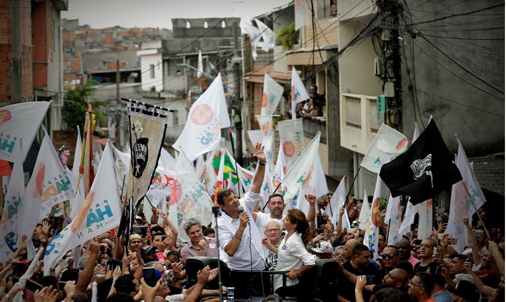 SAO PAULO (BRASIL), 27/10/2018.- El candidato a la presidencial de Brasil, el progresista Fernando Haddad (c), acompañado de su esposa Estela Haddad, participa en su último acto de campaña hoy, sábado 27 de octubre de 2018, en la favela de Heliopolis, una