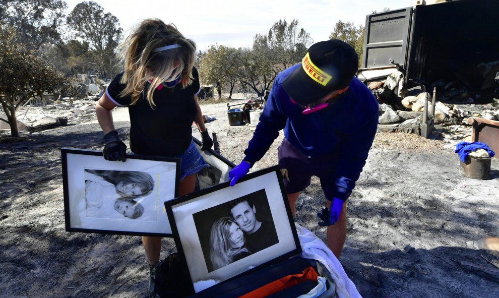 Katherine Marinara y su hijo Luca rescatan de las cenizas viejas fotografías familiares en Busch Drive, Malibu.- AFP