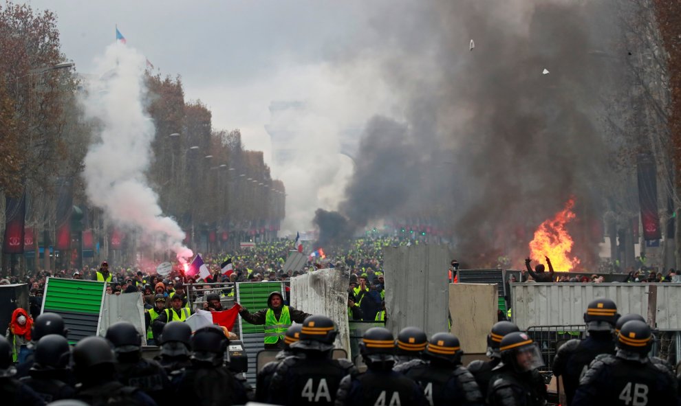 Miles de manifestantes se enfrentan a la Policía en los Campos Elíseos de París durante la manifestación de los "chalecos amarillos".-REUTERS/Gonzalo Fuentes