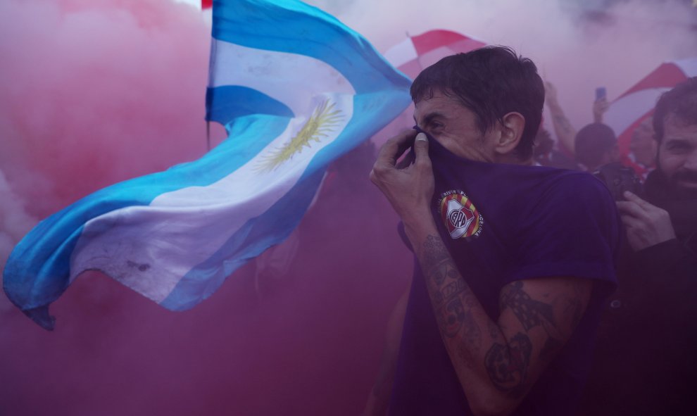 Un aficionado de River se tapa para no respirar el humo de una bengala.- REUTERS/Susana Vera