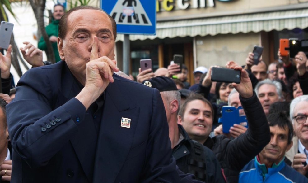 El ex primer ministro italiano Silvio Berlusconi saluda a su simpatizantes durante su visita este viernes a Cerdeña, un día después de anunciar su candidatura a las elecciones europeas de mayo, una decisión que toma a sus 82 años y con su partido en horas
