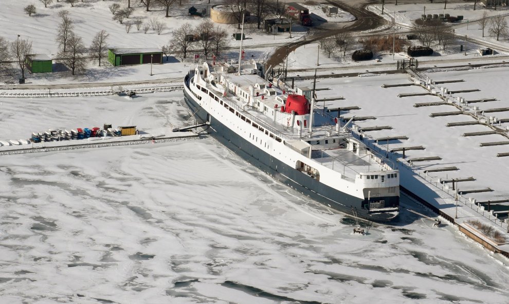 El hielo rodea un barco a lo largo de la orilla del lago Michigan, cerca del centro de la ciudad, ante la bajada de temperaturas a mínimas de -30 grados | AFP/Scott Olson