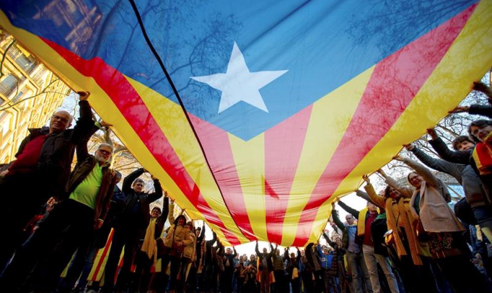 Manifestantes portan una gran estelada durante la movilización. EFE/Enric Fontcuberta