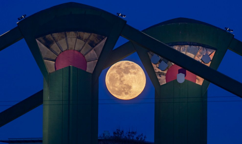 La Super Luna se puede ver detrás de los pilares del puente Floesserbruecke en Frankfurt am Main, Alemania occidental | AFP/ Frank Rumpenhorst