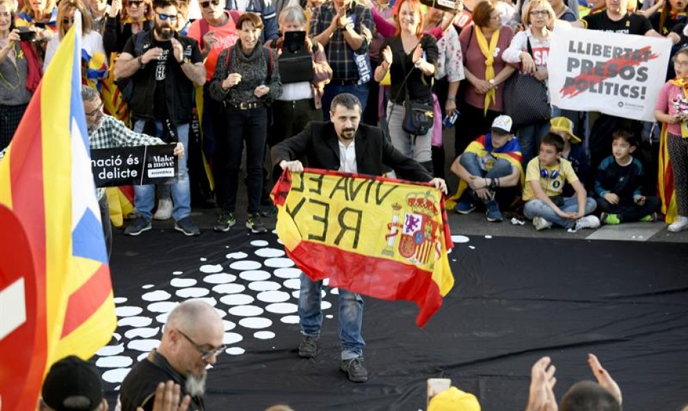 Un hombre con una bandera de España durante la manifestación que bajo los lemas "Autodeterminación no es delito" y "Democracia es decidir" ha sido convocada por más de sesenta colectivos sociales, organizaciones del 15M, entidades republicanas y antifasci