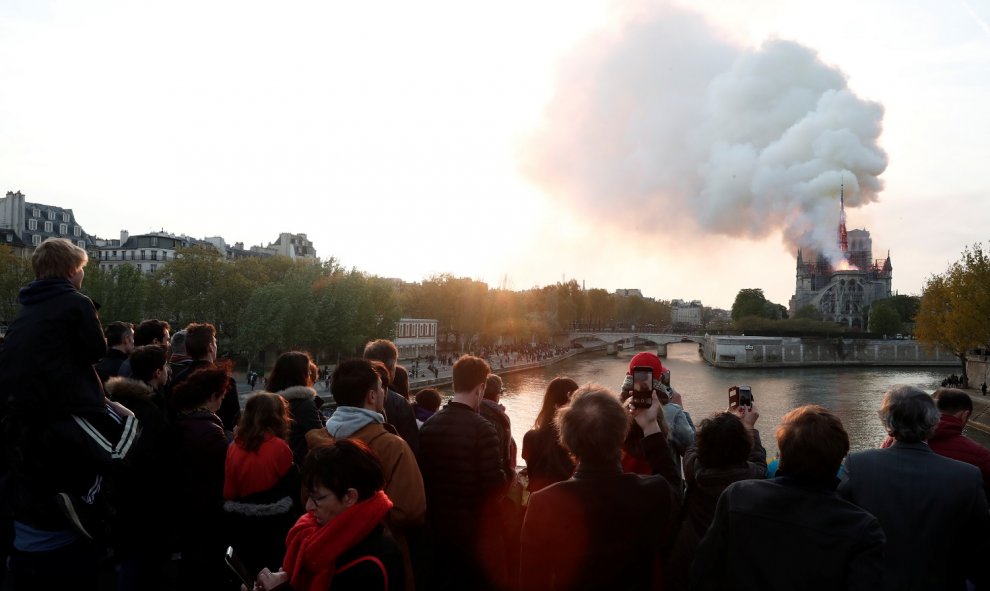 Gente mirando el incendio de la catedral de Notre Dame. Reuters