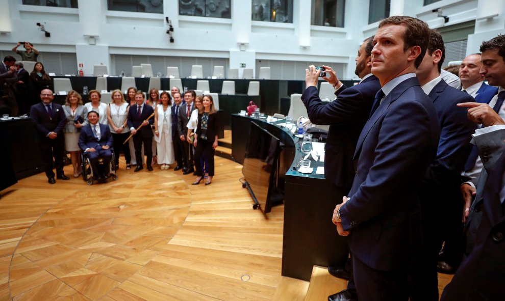 El presidente del Partido Popular, Pablo Casado,d., en el salón de plenos del Ayuntamiento de Madrid donde hoy se ha celebrado la sesión constituyente del nuevo ayuntamiento y en el que el candidato popular José Luis Martínez Almeida ha sido elegido a alc