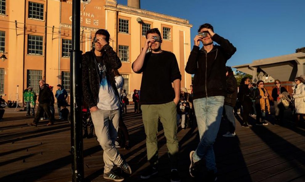 Espectadores observan el sol durante el eclipse solar parcial, este martes en la ciudad de Porto Alegre (Brasil). EFE