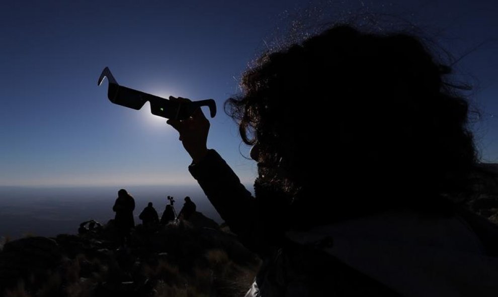Una persona mira sus anteojos especiales durante el Eclipse solar total, este martes, en la ciudad de Merlo, San Luis (Argentina). EFE