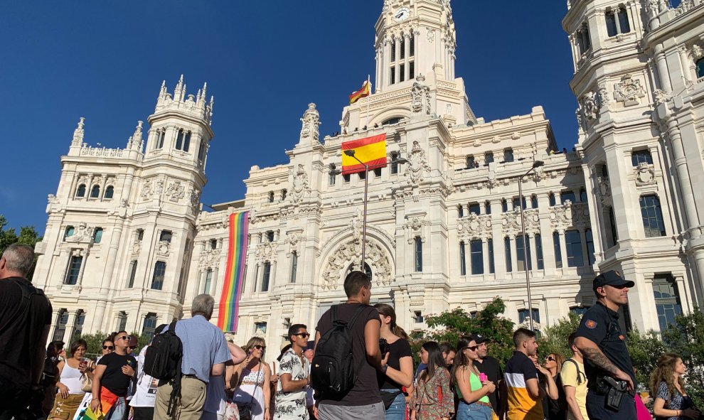 Miles de personas esperan al paso de las carrozas del Orgullo 2019 en la plaza de Cibeles, con la sede del Ayuntamiento de Madrid de fondo. /ESTEFANÍA ROSELLÓ