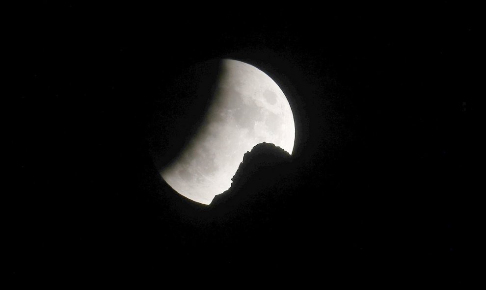 La luna se ve durante un eclipse lunar parcial detrás de un pico en los Alpes suizos del noreste, cerca de Urnaesch, Suiza, el 16 de julio de 2019. Foto tomada el 16 de julio de 2019. REUTERS / Arnd Wiegmann