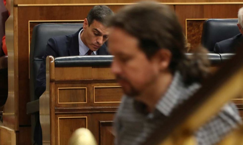 Pablo Iglesias, de camino a la tribuna del Congreso mientras Pedro Sánchez toma unas notas. (J.J. GUILLÉN | EFE)