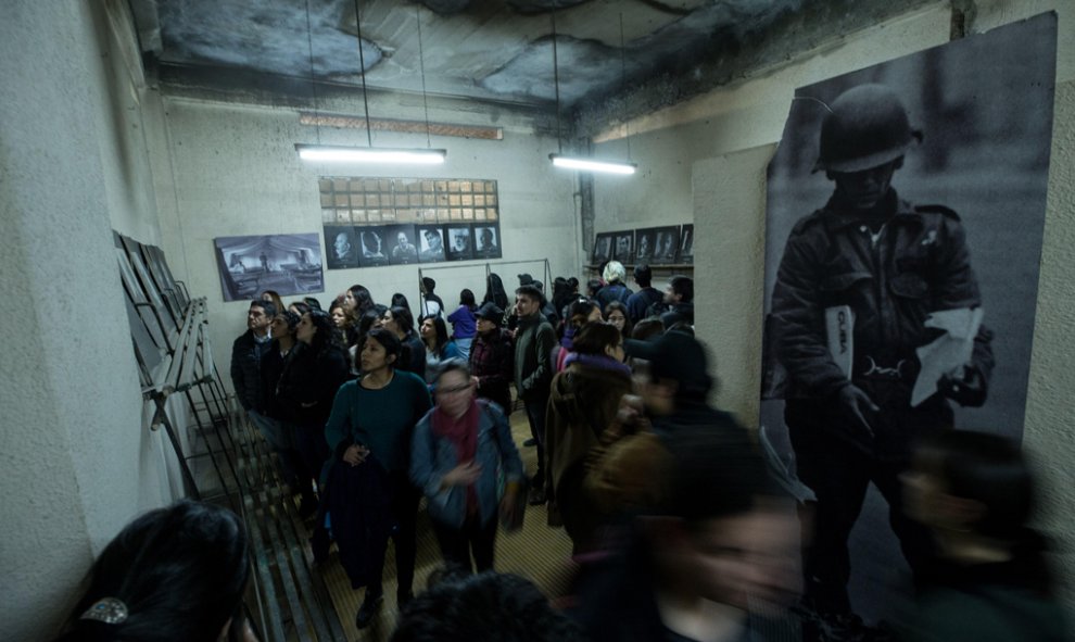 Un grupo de personas visita el Estadio Nacional de Chile, el mayor campo de concentración del país, al que acceden a través de una puerta que se abre una vez al año, la que lleva directamente hasta la grada de la memoria, durante uno de los actos de conme