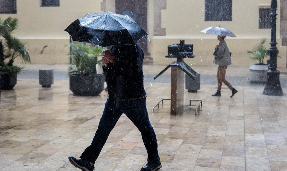 Una persona se protege de la lluvia con un paraguas, esta mañana en València./EFE